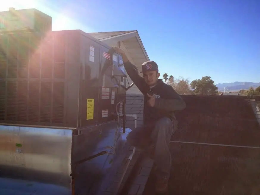 HVAC technician performing AC Tune-Up on a rooftop unit in Fort Madison